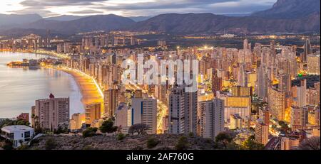 Benidorm Levante Beach promenade au coucher du soleil avec des reflets dans les immeubles de grande hauteur dans le crépuscule de la lumière. Banque D'Images