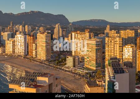 Benidorm Levante Beach promenade au coucher du soleil avec des reflets dans les immeubles de grande hauteur dans le crépuscule de la lumière. Banque D'Images