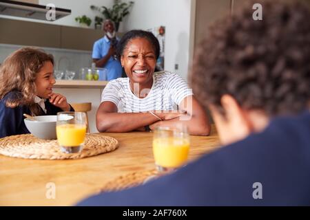 Les grands-parents avec petits-enfants assis dans la cuisine prendre un petit déjeuner avant d'aller à l'école Banque D'Images