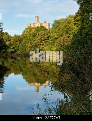 Haut donjon de Château de Warkworth sur colline surplombant la rivière Coquet et rive boisée. Northumberland, Angleterre. Banque D'Images