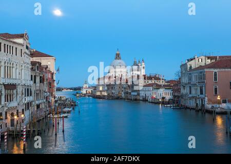 Pleine lune sur le Grand Canal, Venise, Vénétie, Italie à twilightwith la réflexion sur l'eau et vue sur Basilique Santa Maria della Salute Banque D'Images