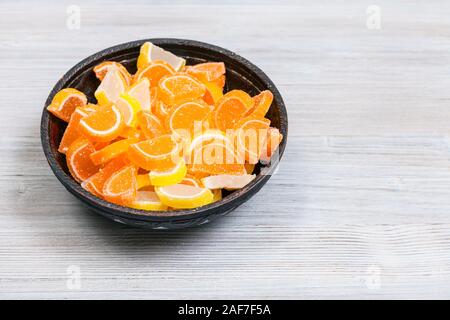 Sucre sucré citron et la marmelade d'orange en tranches sur le bol en céramique de table en bois gris Banque D'Images