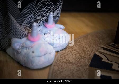 Femme ou fille portant une jolie peluche chaussons en forme de licorne. Banque D'Images