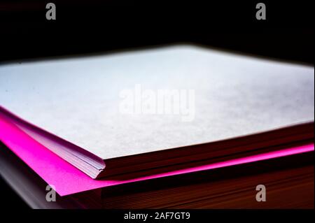 Feuille de couleur unique dans une pile de papier blanc ordinaire Banque D'Images