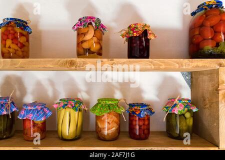 Fermer les pots avec légumes marinés et les champignons pour la vente au marché local Banque D'Images