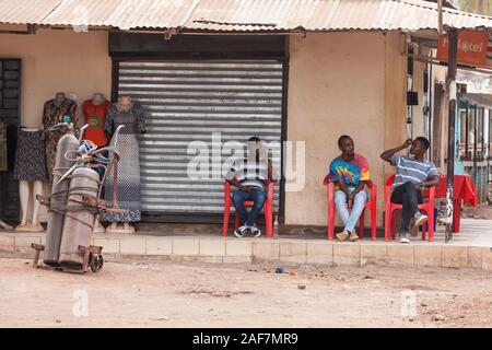 La Tanzanie, le MTO wa Mbu Scène de rue, trois jeunes hommes se détendre. Banque D'Images