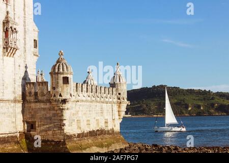 Lisbonne, Portugal : un bateau sur l'estuaire du Tage sails passé la Tour de Belém conçu en 1515 par Francisco de Arruda à mê Banque D'Images