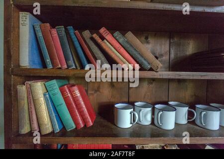 Des étagères dans la classe contenant des messages non lus livres conservés depuis les années 30 dans le village abandonné de Tyneham, Dorset, England, UK Banque D'Images