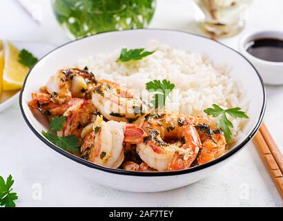 Crevettes grillées et de riz bouilli. Queues de langoustines, orange et la sauce à l'ail avec le persil. Banque D'Images