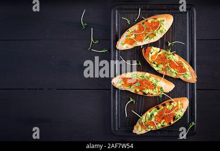 Sandwiches au saumon caviar rouge et salsa à l'avocat. Sandwich pour le déjeuner. La nourriture délicieuse. Vue de dessus, les frais généraux Banque D'Images