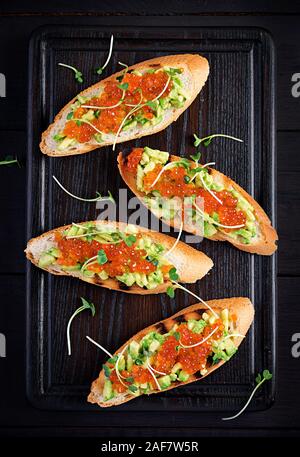 Sandwiches au saumon caviar rouge et salsa à l'avocat. Sandwich pour le déjeuner. La nourriture délicieuse. Vue de dessus, les frais généraux Banque D'Images