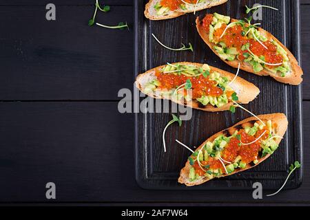 Sandwiches au saumon caviar rouge et salsa à l'avocat. Sandwich pour le déjeuner. La nourriture délicieuse. Vue de dessus, les frais généraux Banque D'Images