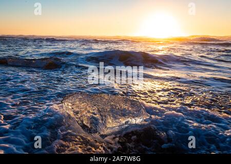 La fonte des icebergs au lever du soleil sur la plage de Volcan noir glacier Jökulsárlón lagoon, Iceland Banque D'Images