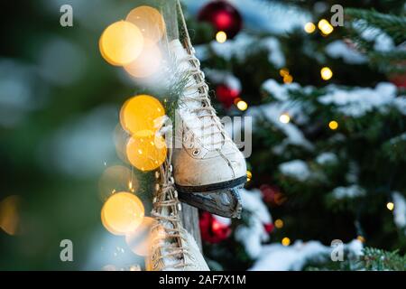 À la maison, décorées avec des décorations de Noël, une paire de patins accrochés. Arbre de Noël de flou artistique en arrière-plan - image Banque D'Images
