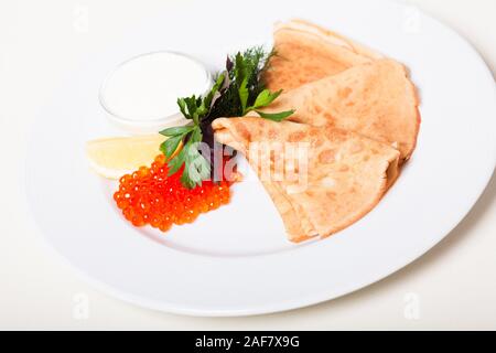 Crêpes traditionnelle russe avec caviar rouge et crème sure Banque D'Images