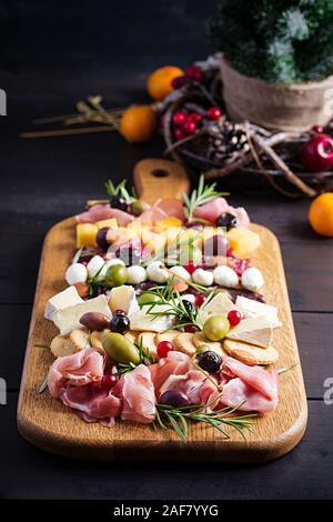 L'antipasto platter avec jambon, jambon, salami, fromage, craquelins et des olives sur un fond de bois. Table de Noël. Banque D'Images