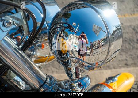 Man taking picture, reflétée dans chrome poli luminaire sur moto Harley Davidson. Banque D'Images