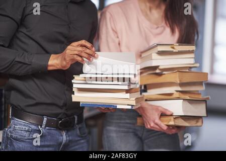 Debout dans des vêtements décontractés. Multiracial students dans la bibliothèque à la recherche de l'information ensemble Banque D'Images