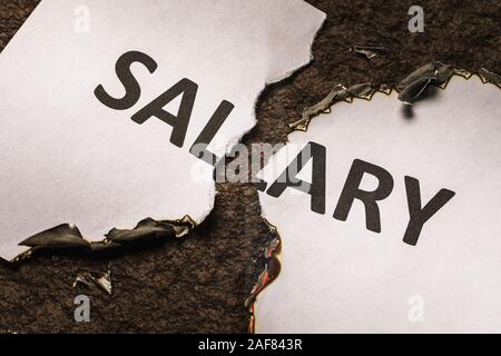 Une feuille de papier est déchiré en deux. Grille de salaire Inscription Banque D'Images