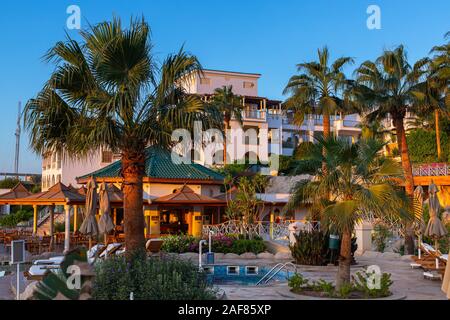 Avis de vacances paradise at tropical resort. Verts juteux, plantes exotiques, resort apartments. L'architecture de l'est à l'aube. Banque D'Images