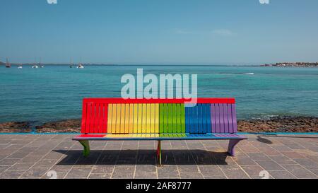 Banc de Arc-en-vue sur les terres à Corralejo, fierté peint couleurs assis ou espace repos, symbole de la communauté LGBT, d'acceptation et de l'inclusivité concept Banque D'Images