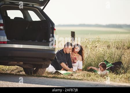 Ambiance calme. Famille ont pique-nique au parc automobile d'argent au coucher du soleil Banque D'Images
