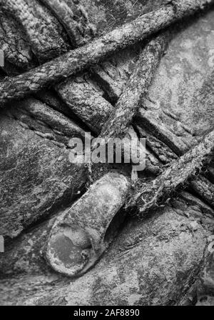 Noir & blanc, close-up shot de lacets boueux et œillets sur paire de vieux bottes de marche. Métaphore camping, randonnée / trekking, vie en plein air Banque D'Images