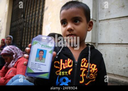 Dhaka, Bangladesh. 13 Décembre, 2019. Un enfant de trois ans, son père montre Atique ID card à la morgue de Dhaka Medical College Hospital à Dhaka.Au moins 13 personnes ont été tuées et près de 20 personnes ont été grièvement blessées lorsqu'un incendie a ravagé une usine de plastiques illégales en dehors de la capitale du Bangladesh Dhaka. Credit : SOPA/Alamy Images Limited Live News Banque D'Images