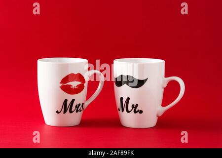 Les tasses avec de la moustache et des lèvres pour la Saint-Valentin sur fond rouge Banque D'Images