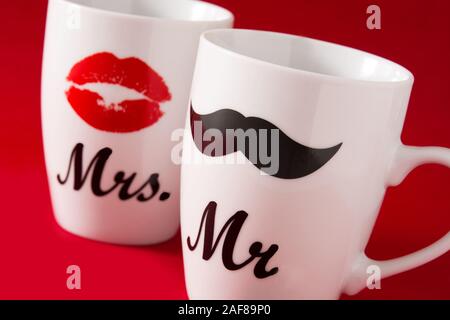 Les tasses avec de la moustache et des lèvres pour la Saint-Valentin sur fond rouge Banque D'Images