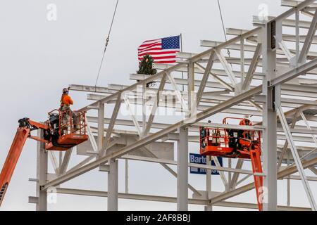 Detroit, Michigan, USA - 13 décembre 2019 - Les travailleurs de la construction soulever un drapeau et un arbre de Noël sur le dernier morceau de l'acier d'être placé sur la nouvelle Chrysler Fiat de l'usine de montage automobile. C'est la première nouvelle usine de montage à être construit à Detroit en 30 ans. Crédit : Jim West/Alamy Live News Banque D'Images
