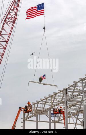 Detroit, Michigan, USA - 13 décembre 2019 - Les travailleurs de la construction soulever un drapeau et un arbre de Noël sur le dernier morceau de l'acier d'être placé sur la nouvelle Chrysler Fiat de l'usine de montage automobile. C'est la première nouvelle usine de montage à être construit à Detroit en 30 ans. Crédit : Jim West/Alamy Live News Banque D'Images