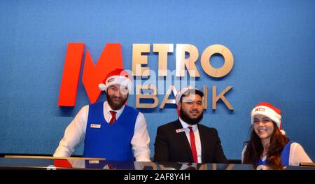 Le 13 décembre, 2019, Metro Bank ouvre une nouvelle succursale à Market Street, Manchester, Royaume-Uni. Personnel porte des chapeaux de Noël pour accueillir les clients. Banque D'Images