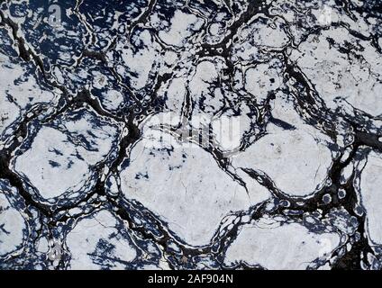 Des fissures dans la peinture blanc patiné sur la surface asphaltée dans un terrain de stationnement urbain Banque D'Images