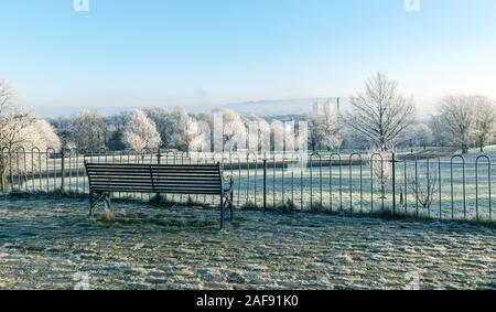 Banc vide donnant sur Queen's Park, Glasgow, Écosse sur un matin d'hiver glacial et brumeux Banque D'Images