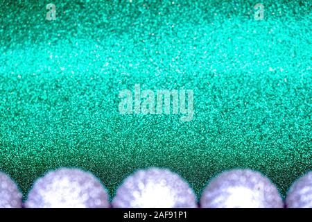 L'argent flou artistique des décorations de Noël sur fond vert turquoise du golfe de Gascogne. Banque D'Images