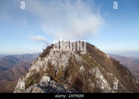 Rocky Mountain peak après un étroit, Rocky Ridge, sec, à la fin de l'automne la végétation et nuageux ciel bleu Banque D'Images