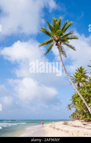 Une jeune femme marchant le long d'une plage paradisiaque dans les Caraïbes Banque D'Images