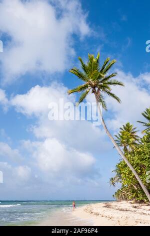 Une jeune femme marchant le long d'une plage paradisiaque dans les Caraïbes Banque D'Images