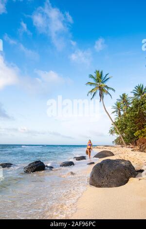 Une femme marche le long d'une plage tropicale idyllique Banque D'Images