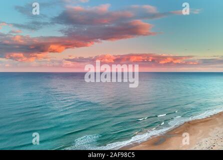 Paysage pittoresque vue aérienne drone point paysage, bleu calme mer Méditerranée coloré doux nuages roses brillant au coucher du soleil ciel soir, Espagne Banque D'Images