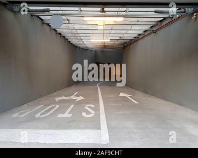 L'entrée et la sortie du garage souterrain public. Flèches d'entrée et de sortie visibles et un stop à la sortie du garage. Cela pourrait signifier l'entrée int Banque D'Images