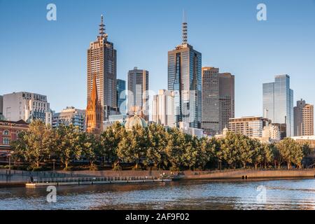 Melbourne, Australie - 17 novembre 2009 : Groupe de gratte-ciel derrière la ceinture de feuillage vert et la rivière Yarra under blue sky. Banque D'Images