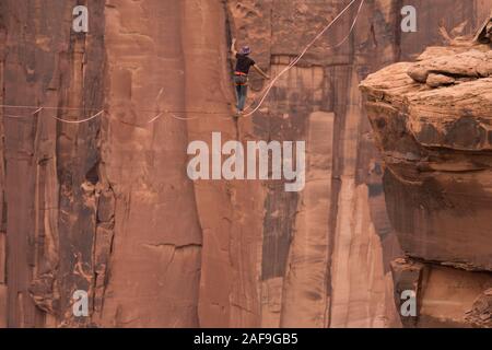 Un jeune homme slackline ou highlining des centaines de pieds au-dessus du Canyon de minéraux près de Moab, en Utah pendant un rassemblement highline. Banque D'Images