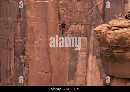 Un jeune homme slackline ou highlining des centaines de pieds au-dessus du Canyon de minéraux près de Moab, en Utah pendant un rassemblement highline. Banque D'Images