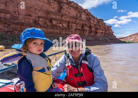 Une grand-mère et sa petite-fille sur une famille voyage de rafting dans le canyon de la Rivière San Juan, dans le sud-est de l'Utah, USA. Banque D'Images