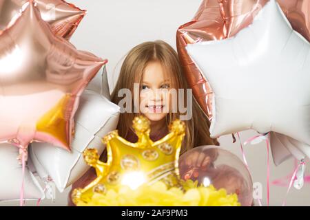 Petite fille jouant avec des ballons. Portrait de petite fille jouant avec des ballons d'air. Happy little girl holding colorful balloons.Smiling kid. Banque D'Images