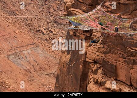 Une femelle cavalier BASE de sauts le ravitailleur SpaceNet suspendu de la falaise verticale de 950 pieds au-dessus de la vallée à minéral Canyon près de Moab Banque D'Images