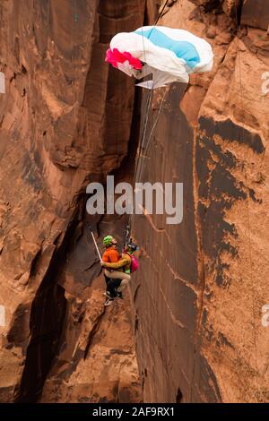 Deux cavaliers de base faisant un 'Mr. Bill' saut en tandem à partir de l'espace Net Mothership 950 pieds au-dessus du plancher de minéral Canyon près de Moab, Utah. Depuis le j Banque D'Images