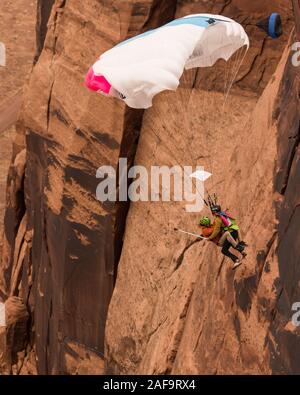 Deux cavaliers de base faisant un 'Mr. Bill' saut en tandem à partir de l'espace Net Mothership 950 pieds au-dessus du plancher de minéral Canyon près de Moab, Utah. Depuis le j Banque D'Images